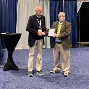 Maxim van Norden (right) is presented with a plaque to commemorate his induction into the U.S. Hydrographer Hall of Fame.