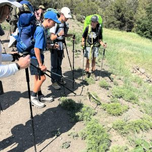 Scouts Patrick Ryan, Nate Pyron and Max Elenbaas observe a 7-foot rattlesnake skin on the side of the trail at Philmont Scout Reservation