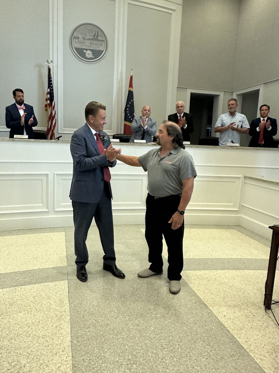 Long Beach Mayor Tim Pierce (left) presents Frank Olaivar with a certificate honoring the local businessman’s twenty-four years of service on the Long Beach Planning and Development Commission.