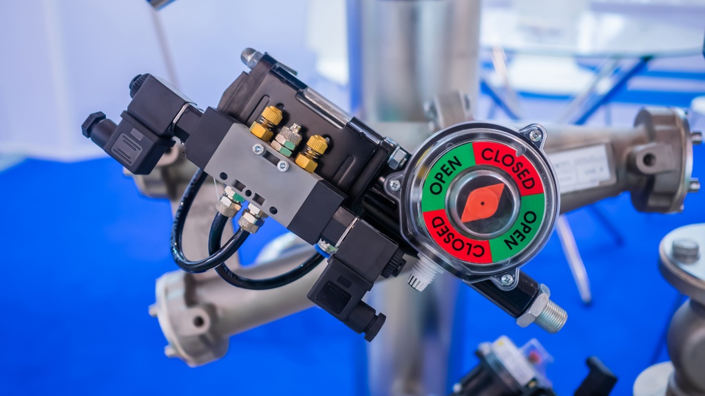 A close-up view shows a black solenoid valve. A circular gauge displays the words "Open" and "Closed" in green and red.