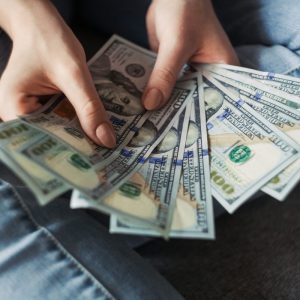 a person holding hundred dollard bills