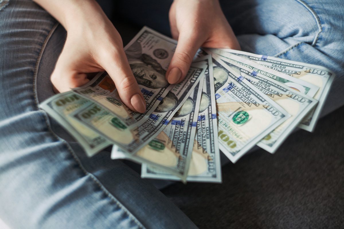 a person holding hundred dollard bills