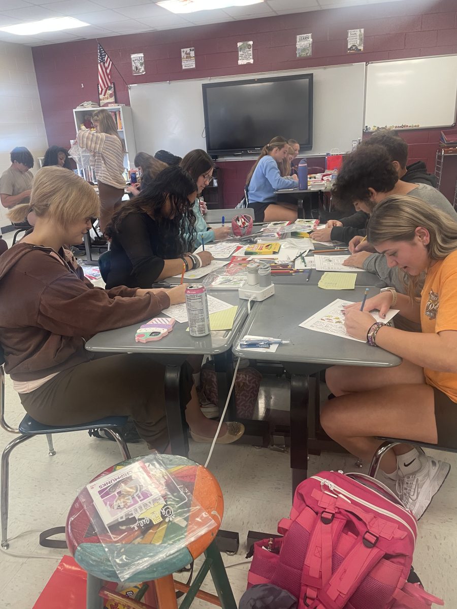 Students are pictured working on personalized bookmarks and handwritten notes for first graders at DES.