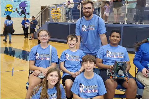 Robotics team tournament champions are pictured with their coach.