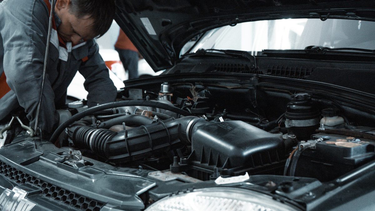 man working under the hood of a car