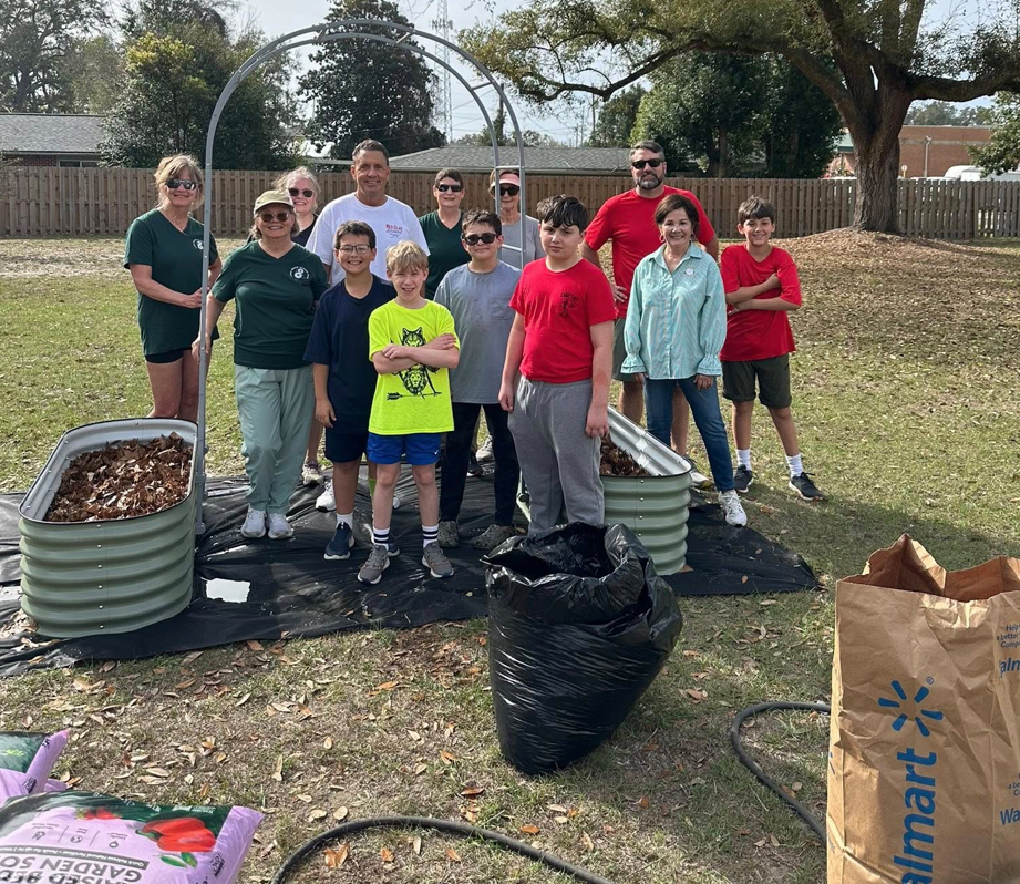 Long Beach Mayor Tim Pierce (center, white shirt) poses with members of the Long Beach Garden Club and scouts with Troop 205 as these volunteers plant a new community garden at historic Greenvale (the Quarles House).