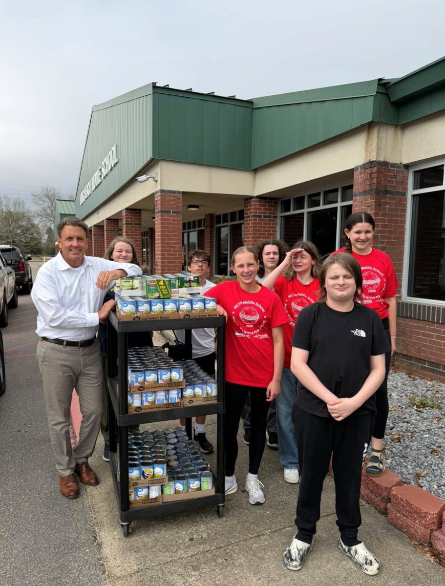 Long Beach Mayor Tim Pierce (left) poses with students and staff at Long Beach Middle School with hundreds of canned green beans collected at the school for this year’s drive.