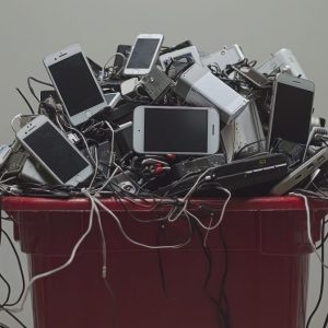 trash can full of electronics being thrown away