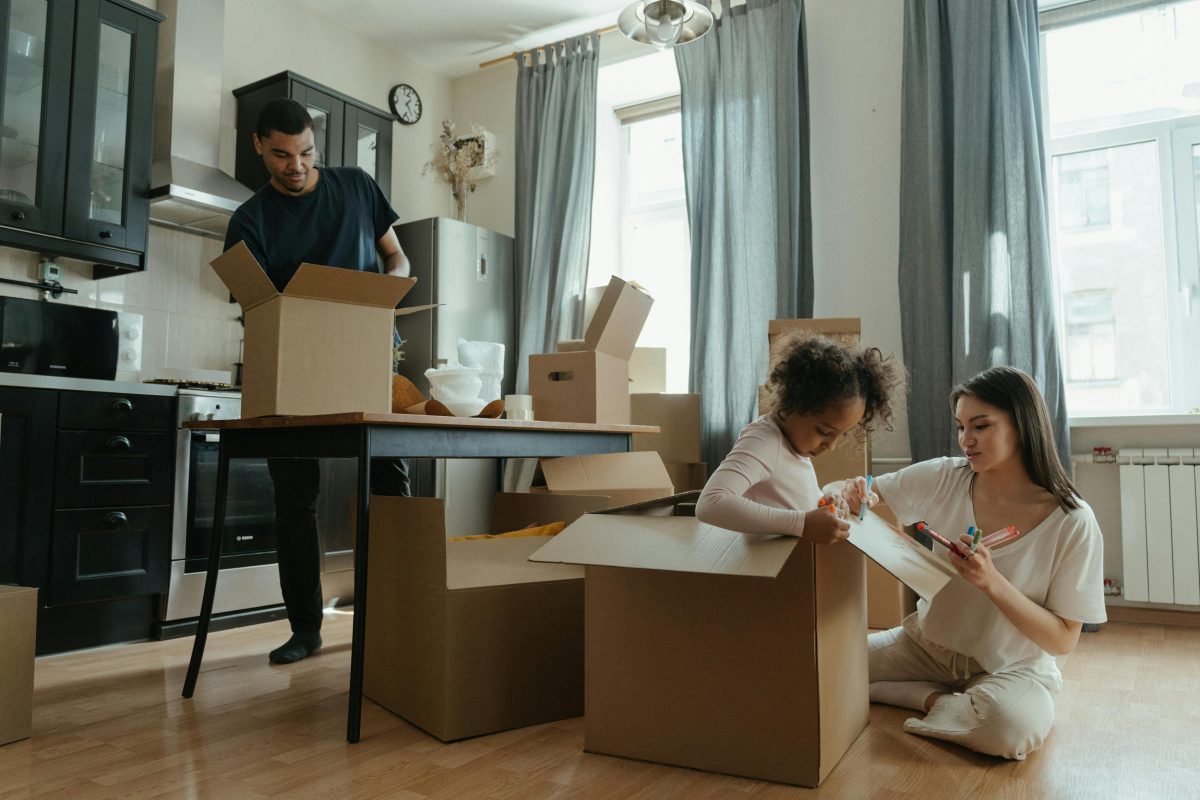kid playing inside of moving boxes throughout the house