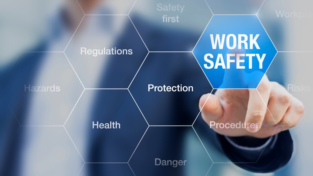 A businessman reaches and presses an octagon labeled "Work Safety" on a digital grid. Other octagons feature related words.