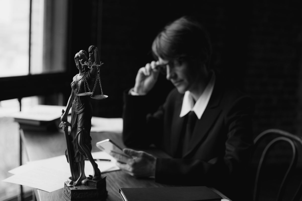 grayscale-photo-of-a-lawyer-using-a-mobile-phon