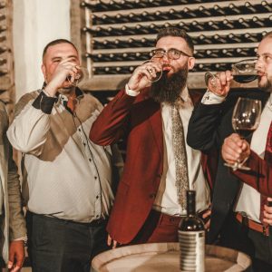 men in suites drinking wine