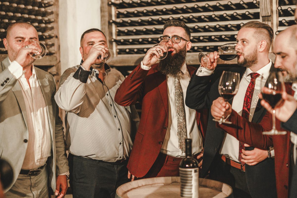 men in suites drinking wine