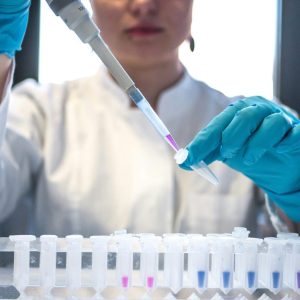 scientist using pipette with test tubes in a lab