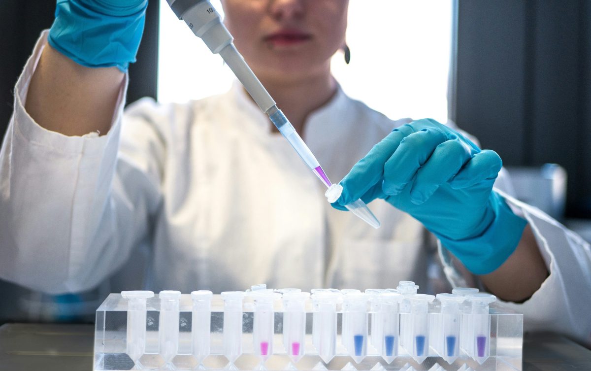 scientist using pipette with test tubes in a lab