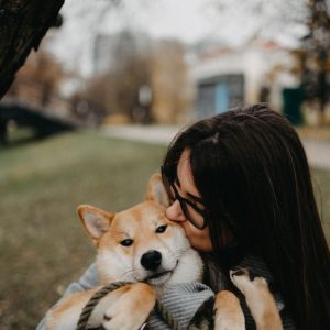 woman kissing her pet dog