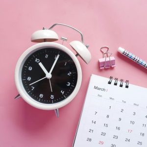 clock and calendar on pink table
