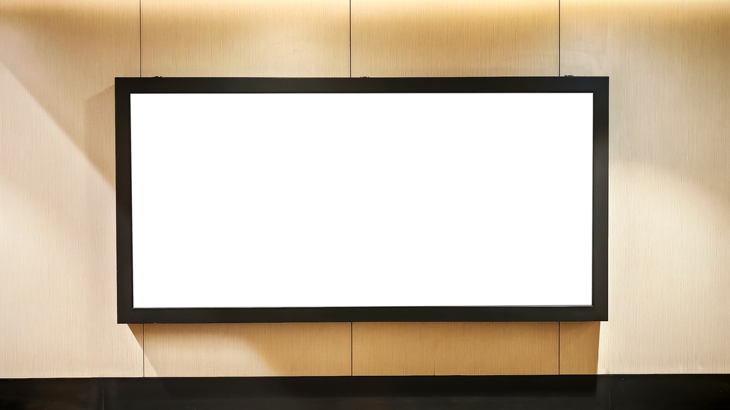 A large, blank horizontal billboard with a black frame is mounted on a wooden wall in a modern indoor hallway.