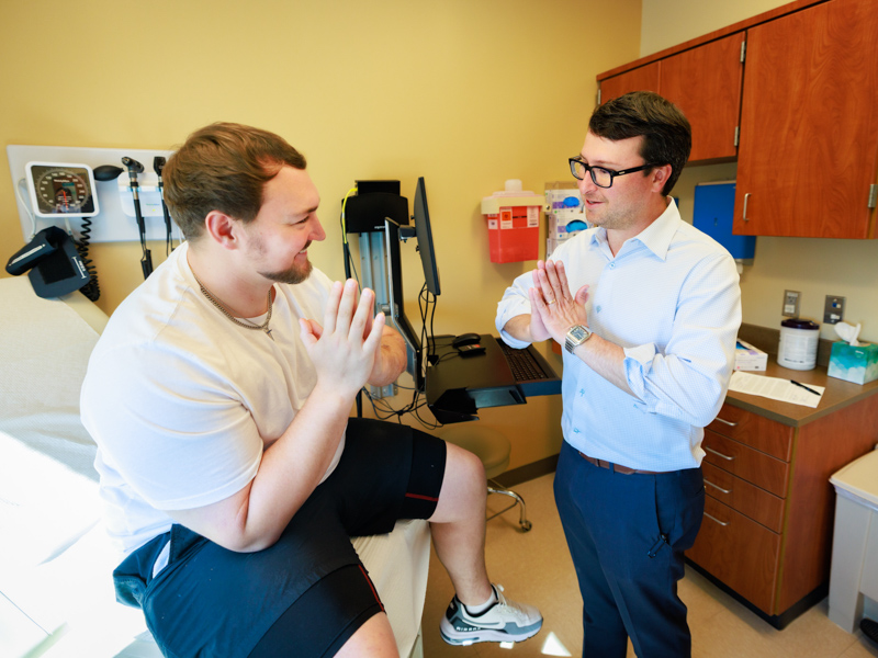 Trey Wheeler, left, meets with Dr. Marc Walker at a follow-up appointment following surgery in March.