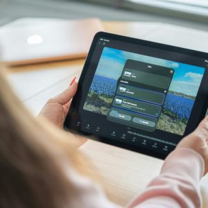 Woman holding a tablet displaying a photo gallery